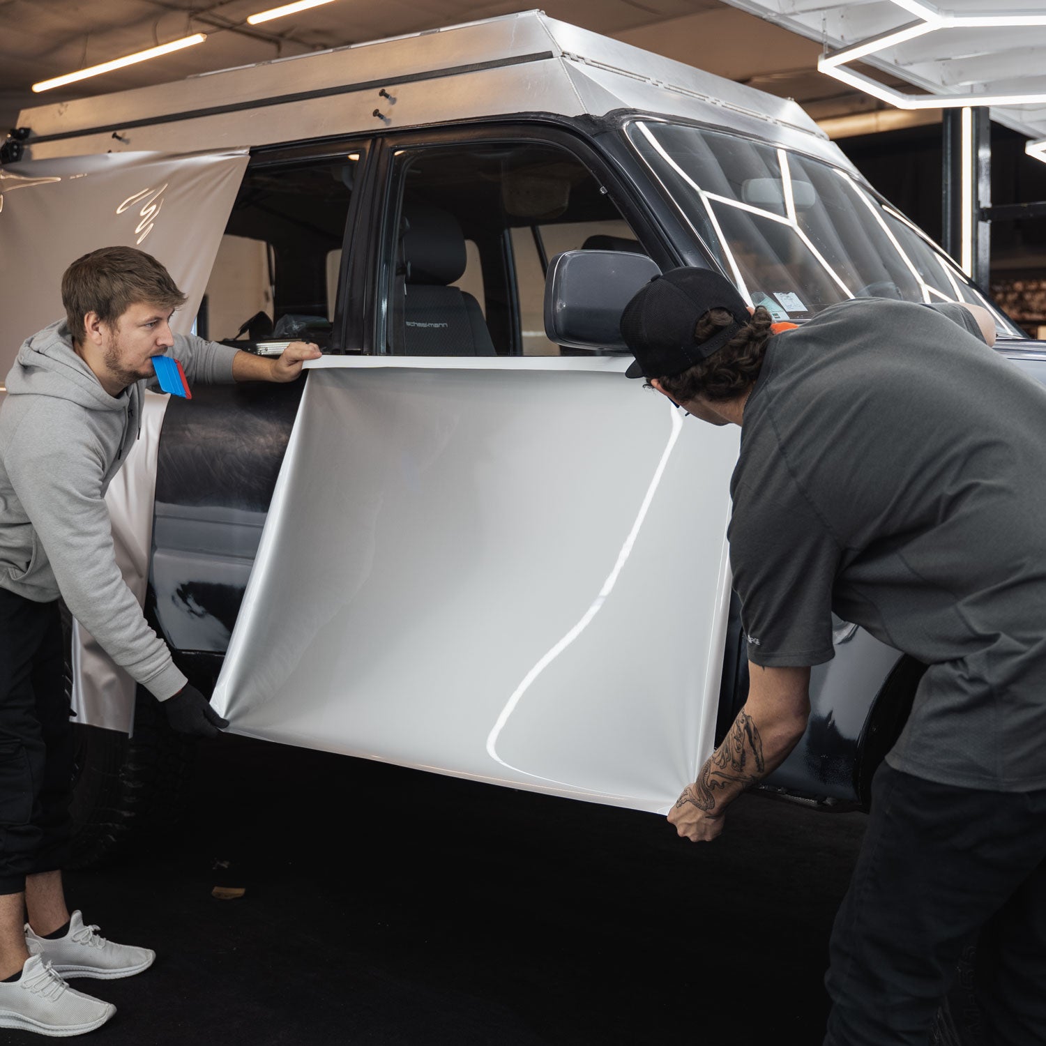 Picture of a Lan Cruiser being wrapped in ARMR Hyper Silver