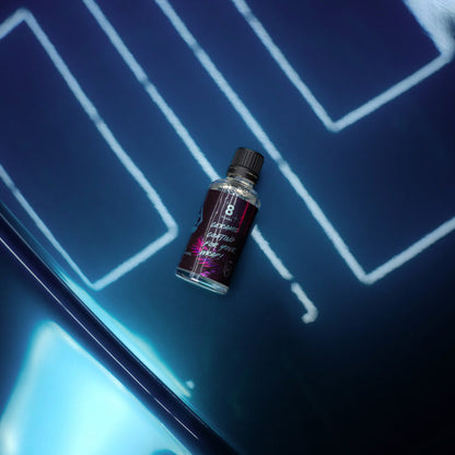 Small bottle on a reflective surface with a blue geometric background